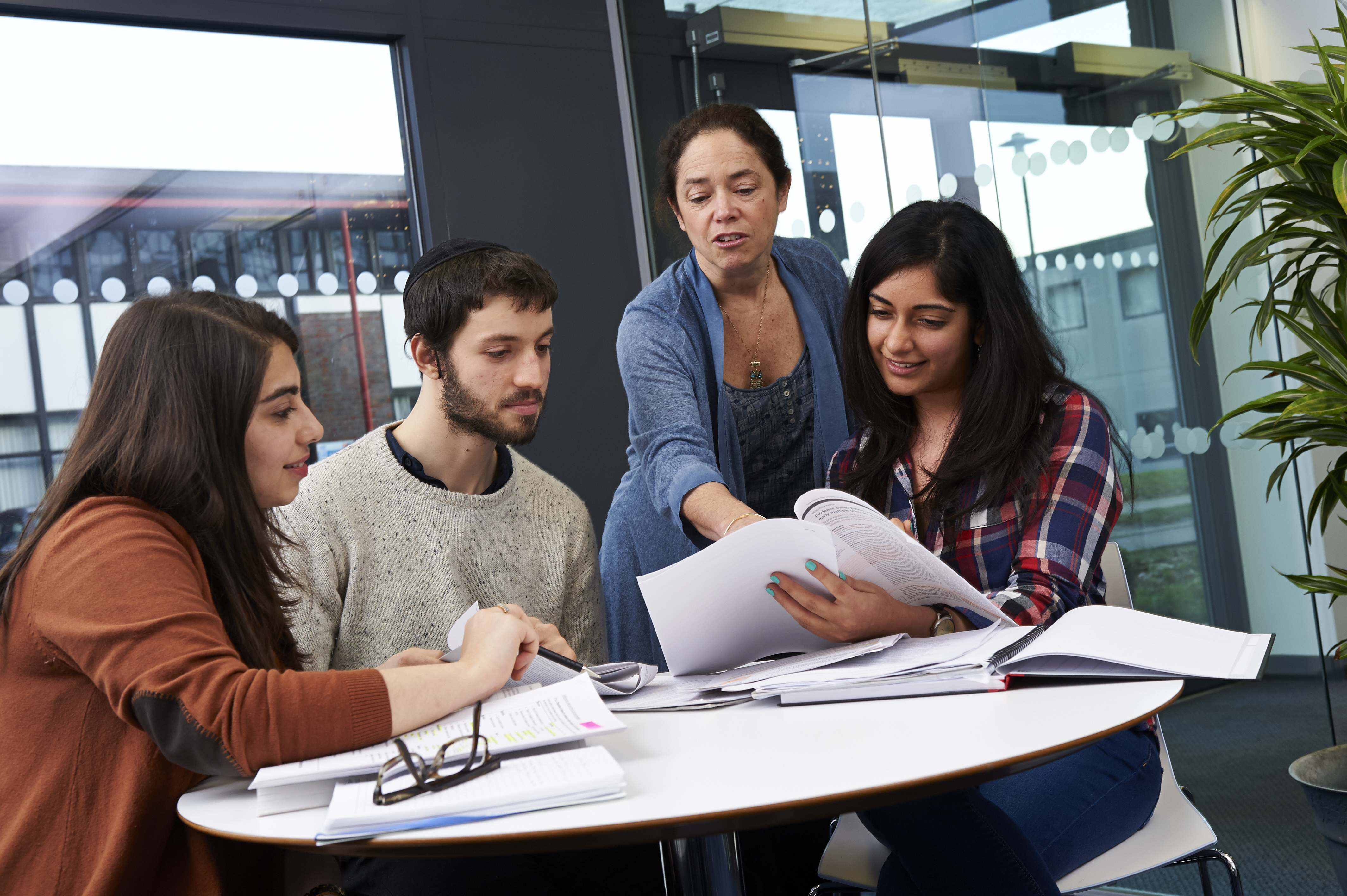 man studying next to a bookshelf - media arts research