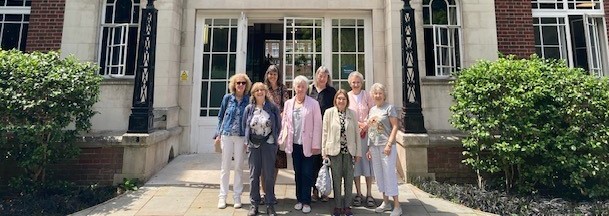 group of Bedfors College alumnae stood in front of a library